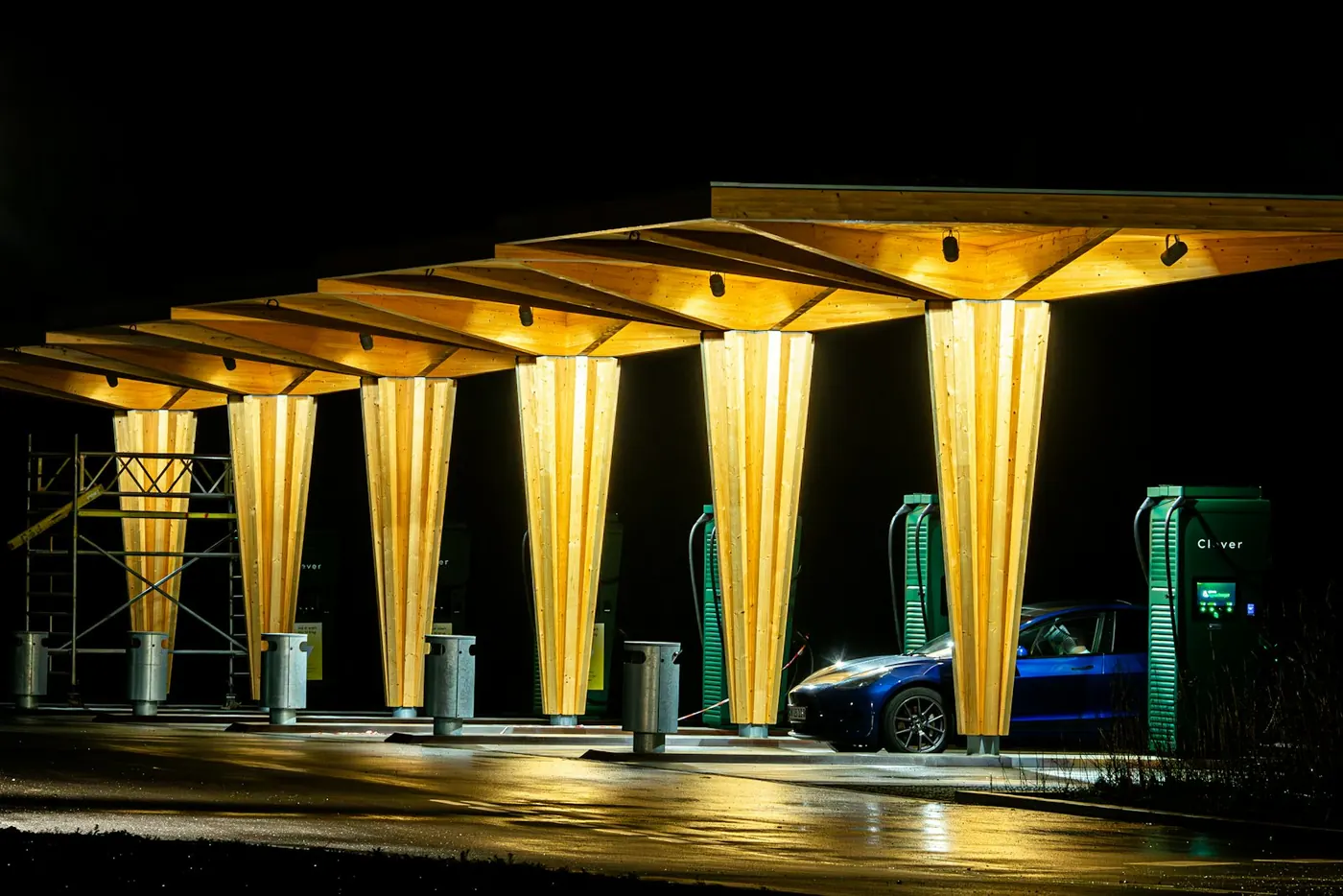 Illuminated EV charging hub at night with a car plugged in
